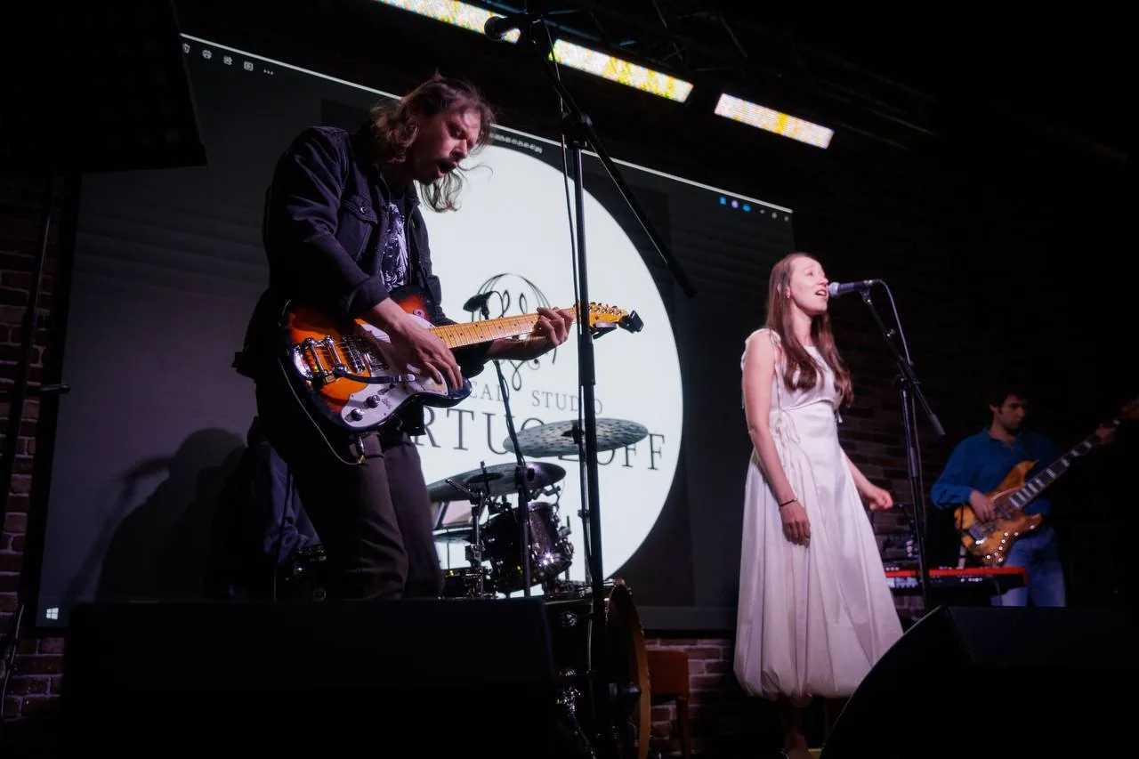 Гитарист выступает с вокалисткой на концерте VIRTUOZOFF